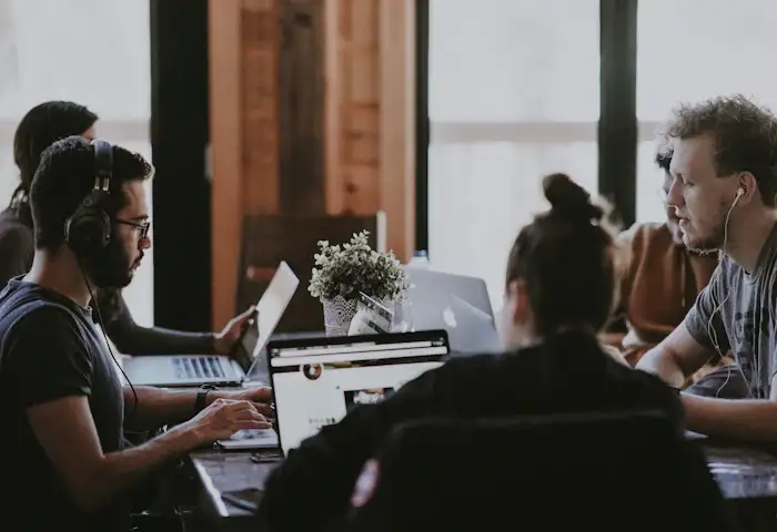 Colleagues wearing headphones working on laptops