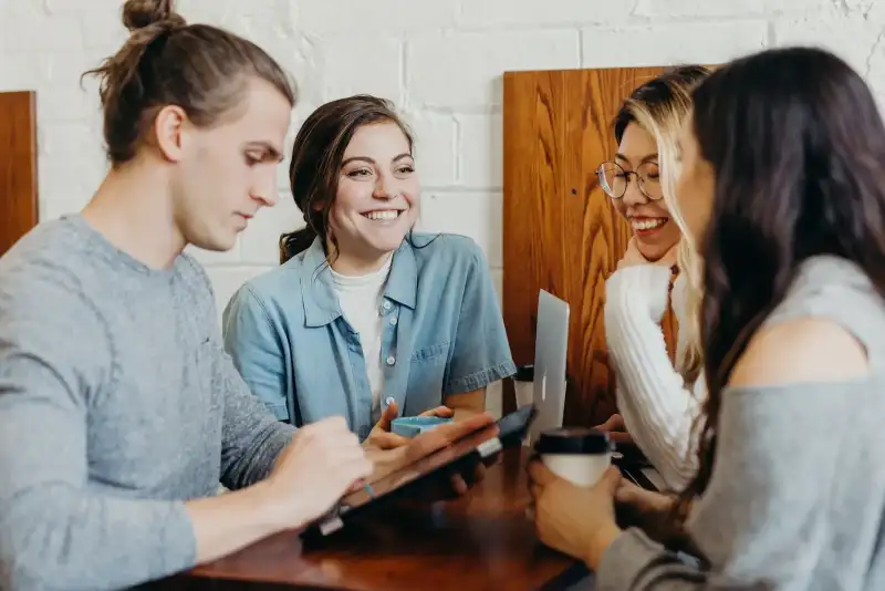 Colleagues smiling and talking around a table