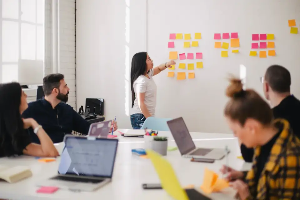 A colleague presenting ideas on sticky notes to her team