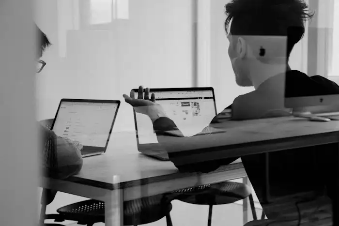 A person working at a laptop in an office, in black and white
