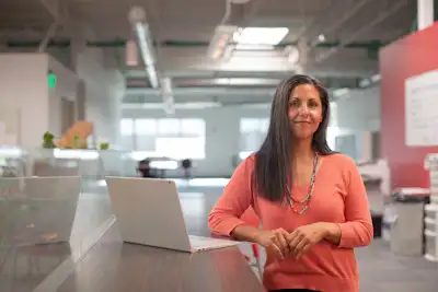 A professional smiling at her desk
